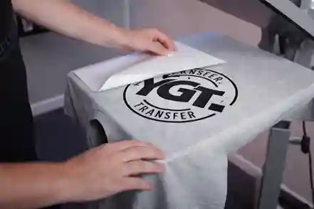 Sarı ve gri tişört üzerine pres makinesi ile uygulanan YGT Transfer baskı aşaması